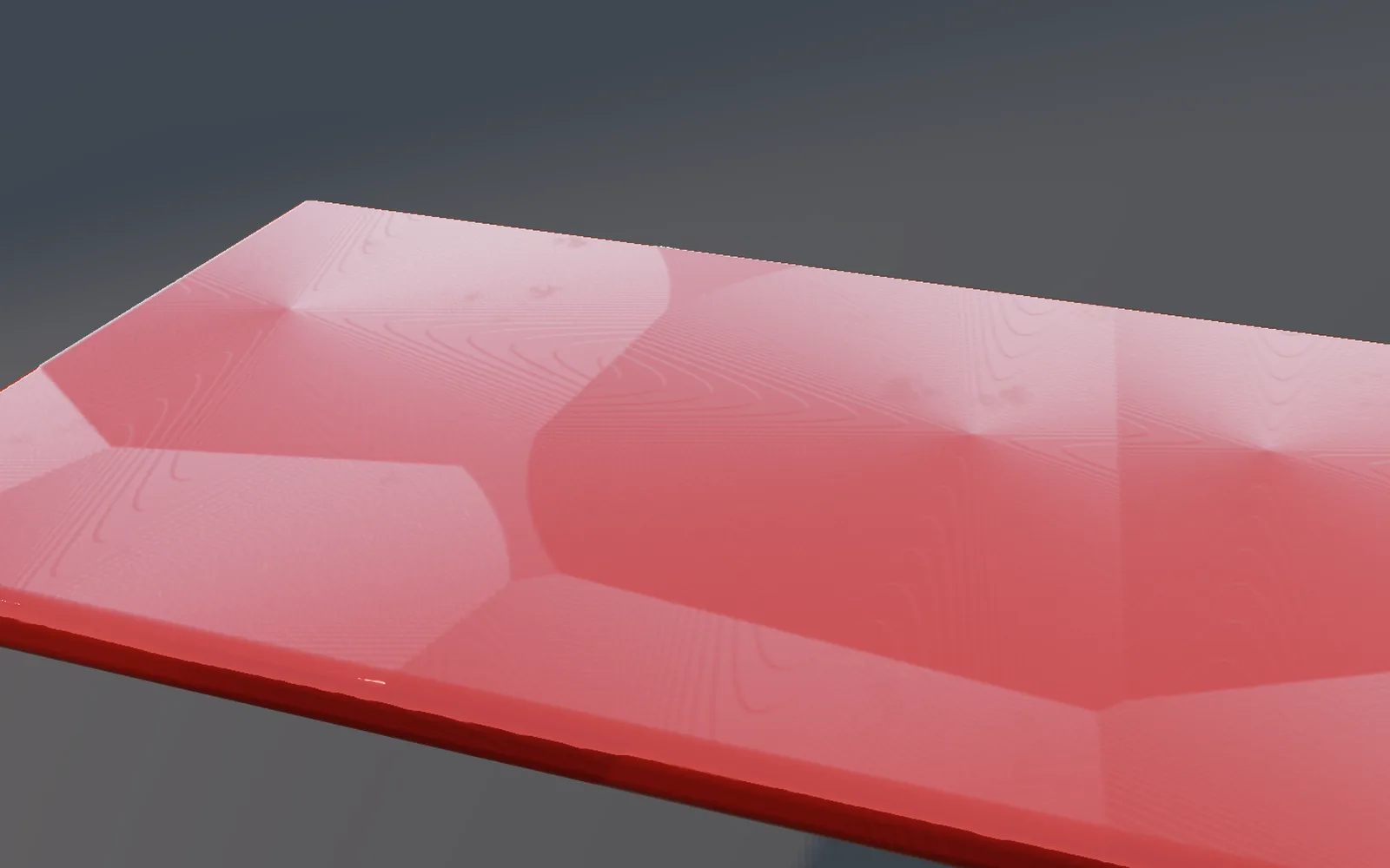 a red painted panel whose dents catch a raking light