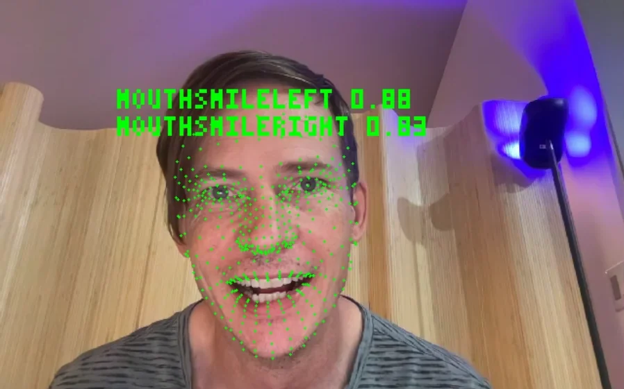 A face on a webcam with tracking points and its smile values read off it
