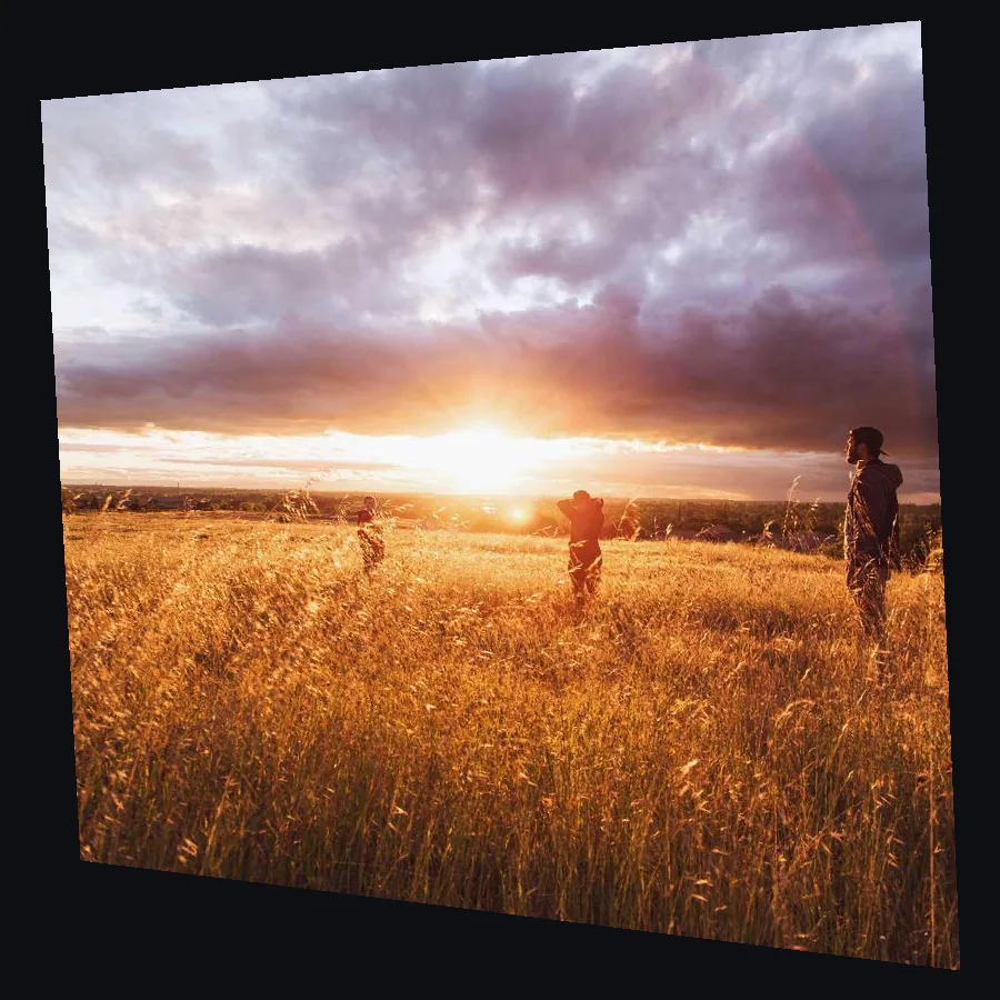 A sunset photo pulled into a slanted shape by its four corners, the way it goes out to a projector sitting off to one side.